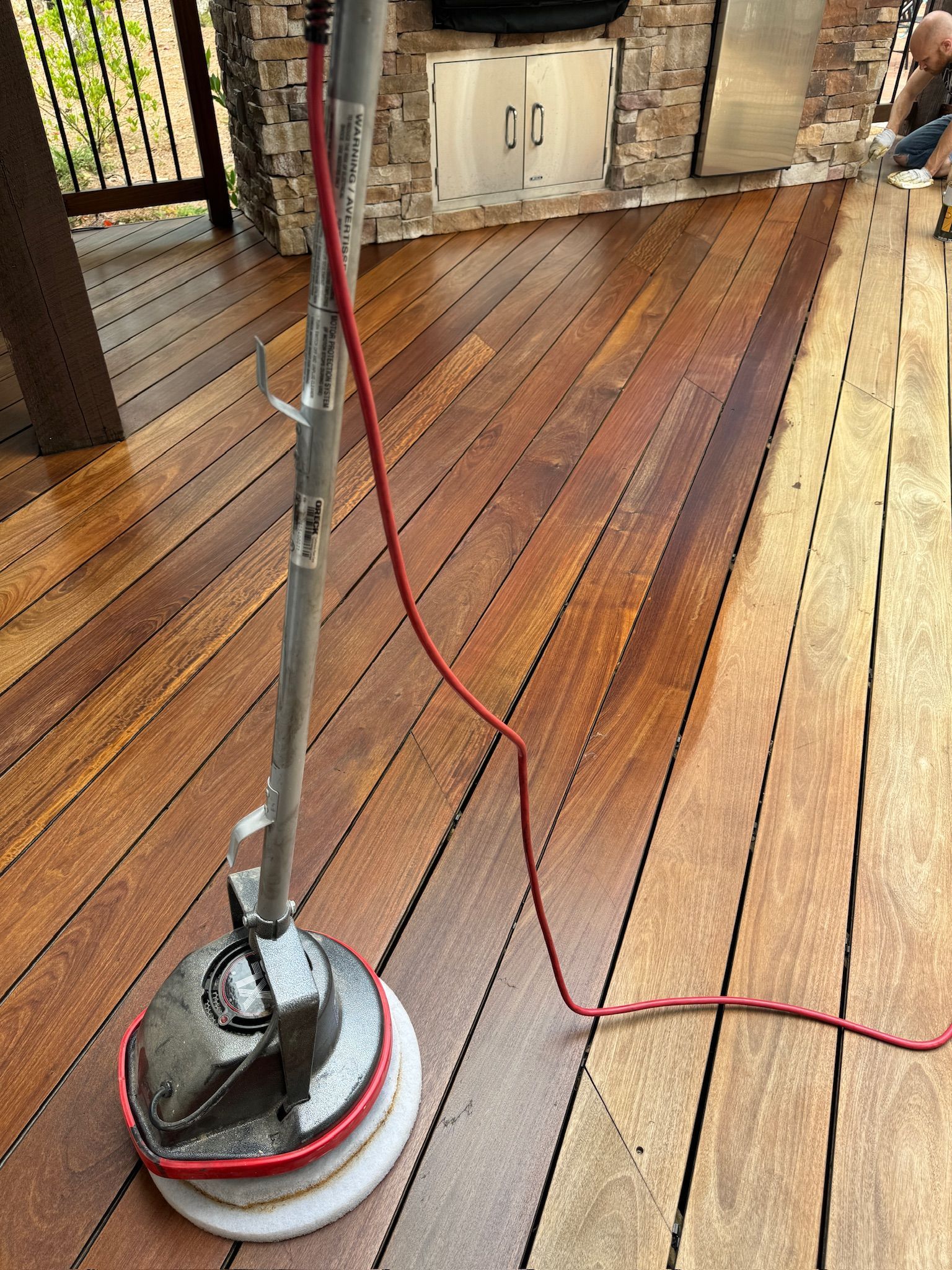A vacuum cleaner is sitting on top of a wooden deck.
