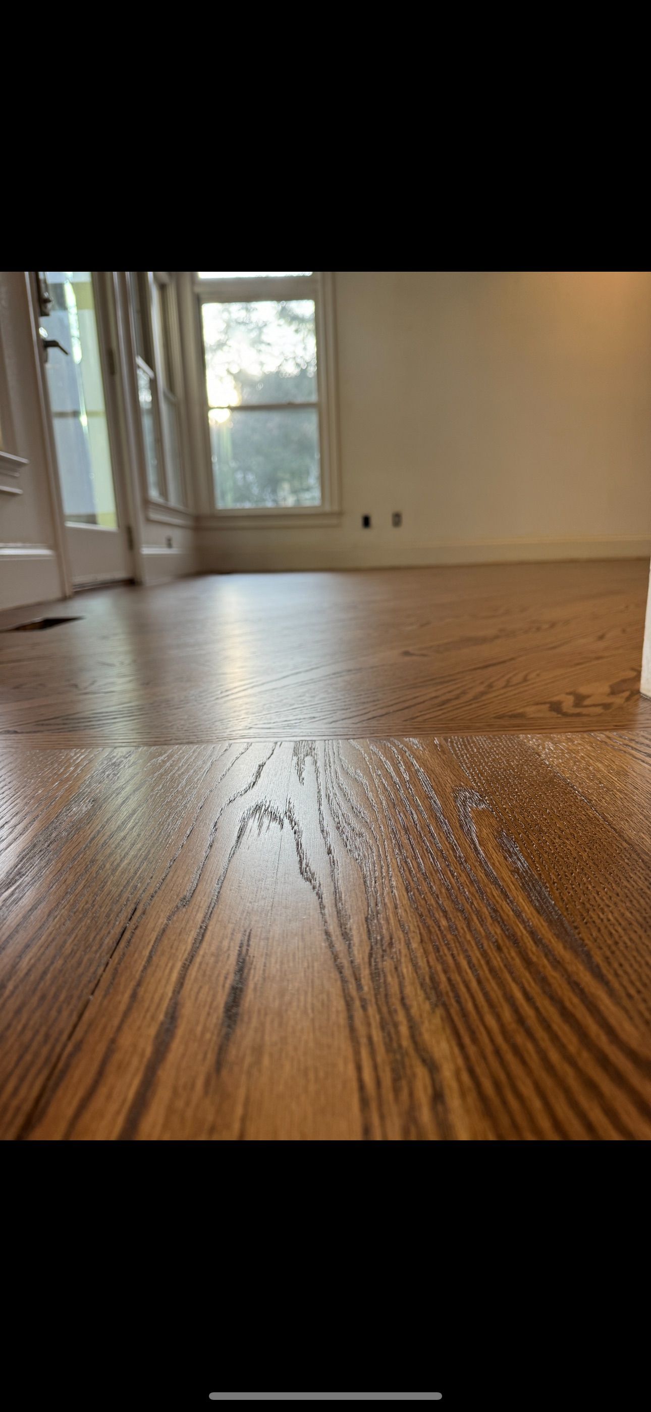 A room with a wooden floor and a window.