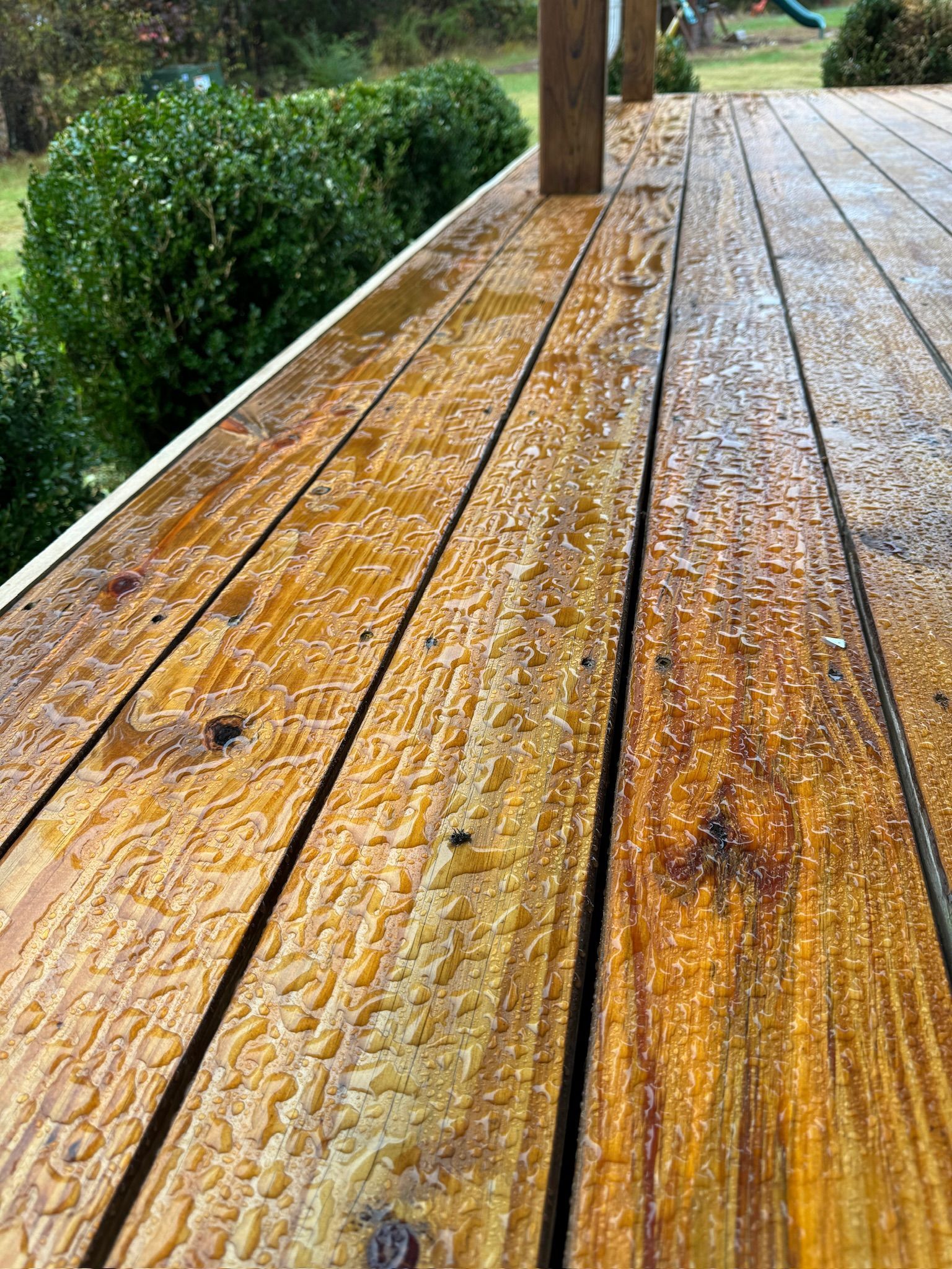 A close up of a wooden deck with water drops on it.