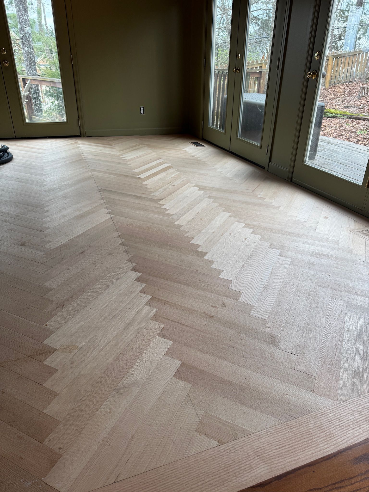 A room with a wooden floor and sliding glass doors.
