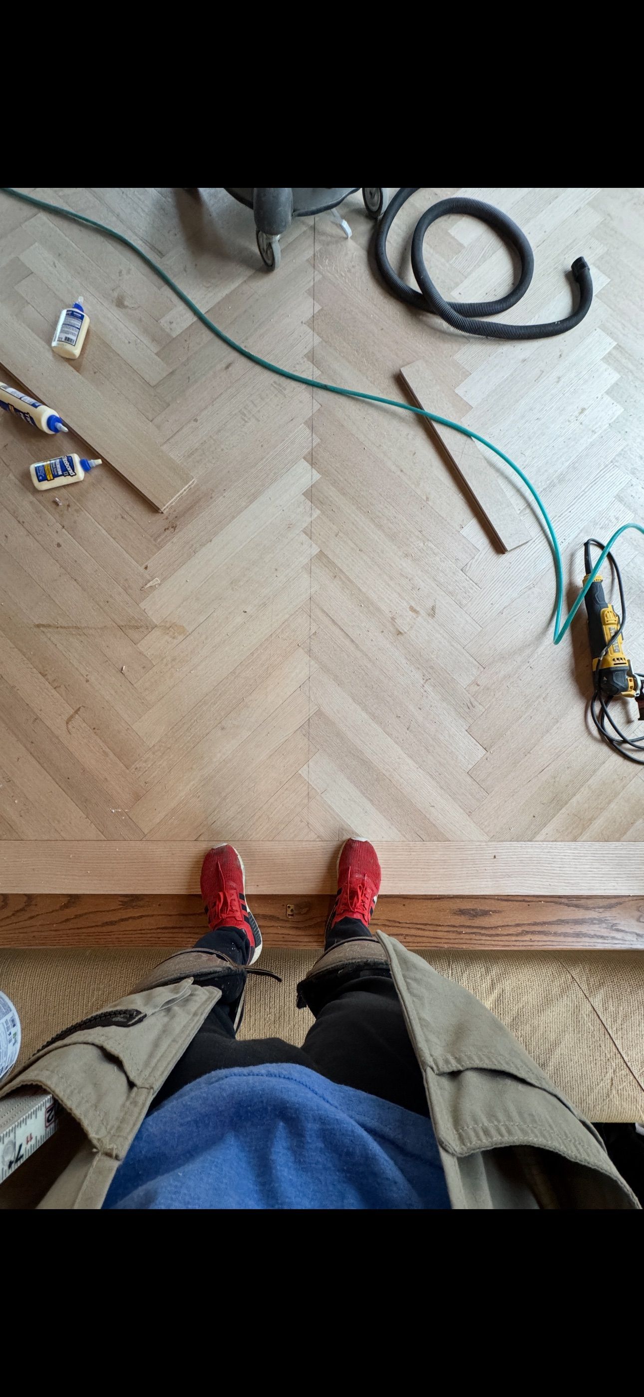 A person is standing on a wooden floor.