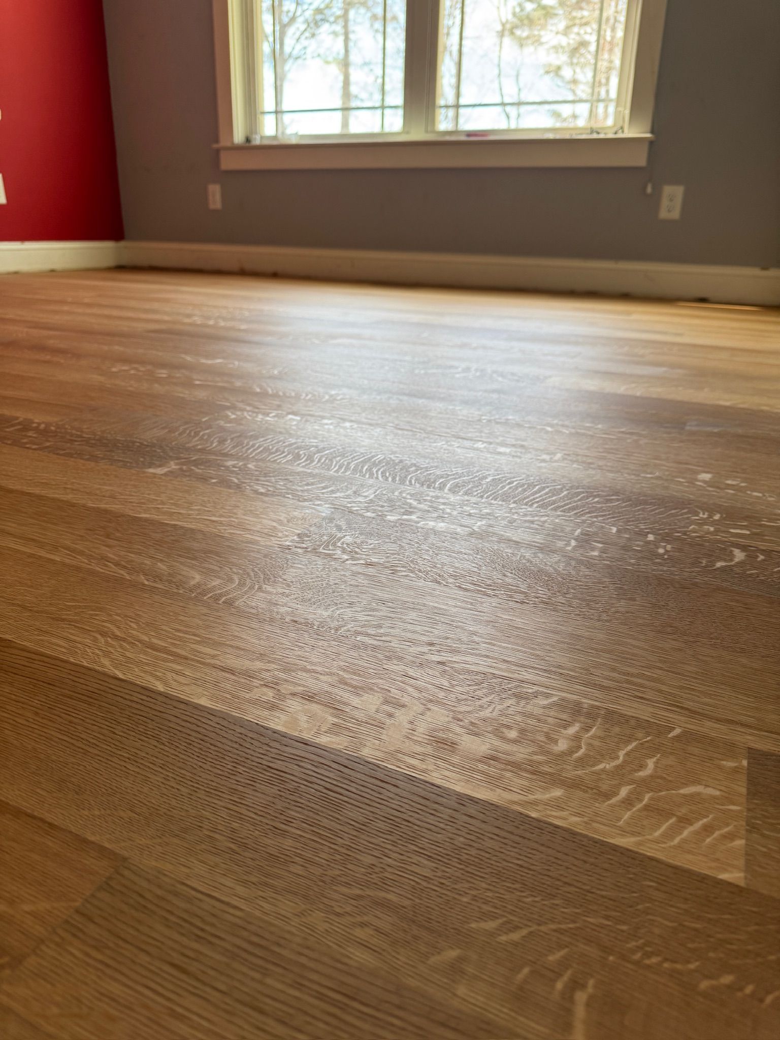 A room with a wooden floor and a window.