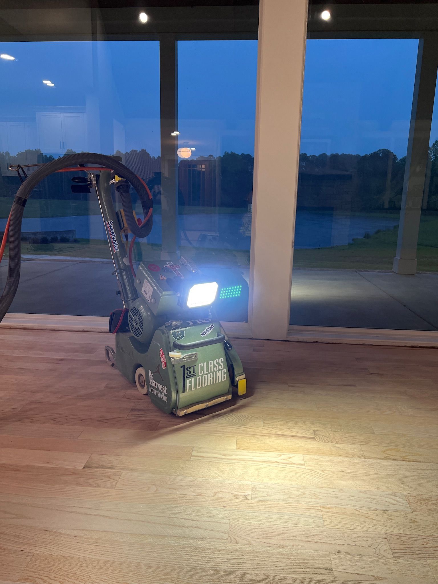 A machine is sitting on a wooden floor in front of a window.