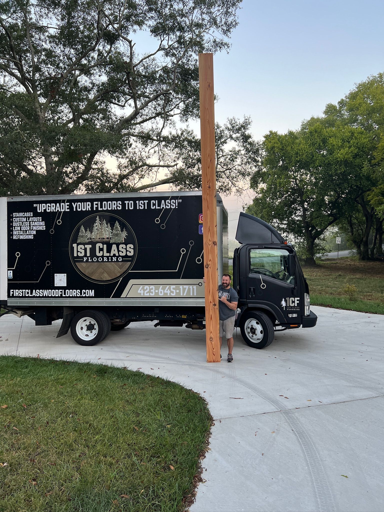 A moving truck is parked in front of a white house.