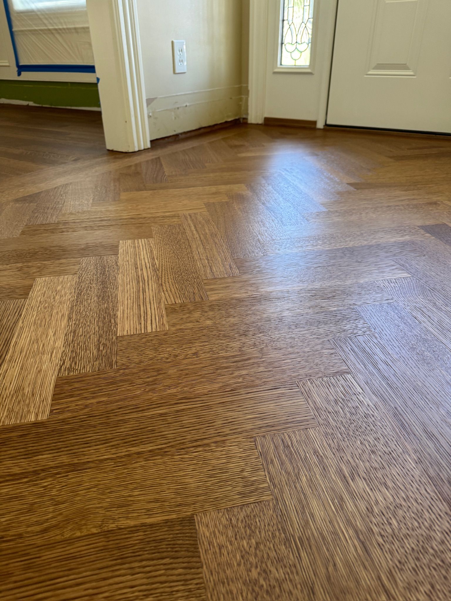 A close up of a wooden floor in a room with a door.