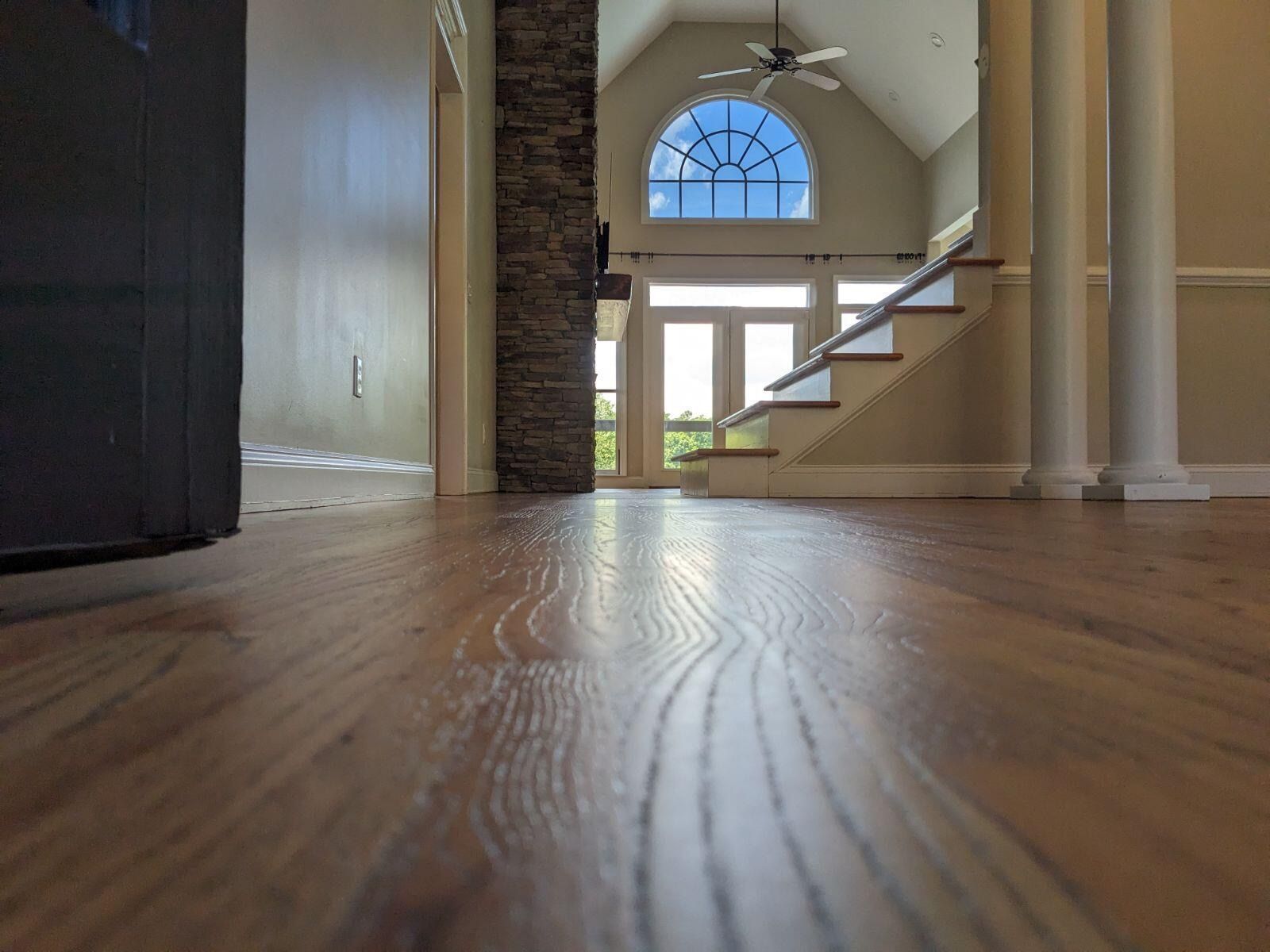 A living room with hardwood floors and stairs leading up to the second floor.
