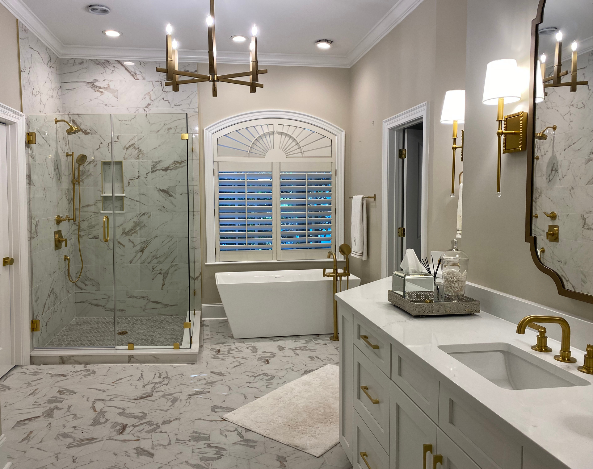 White and gold bathroom featuring a soaking tub with a floor-mount tub filler and sprayer, and a tiled walk-in shower.
