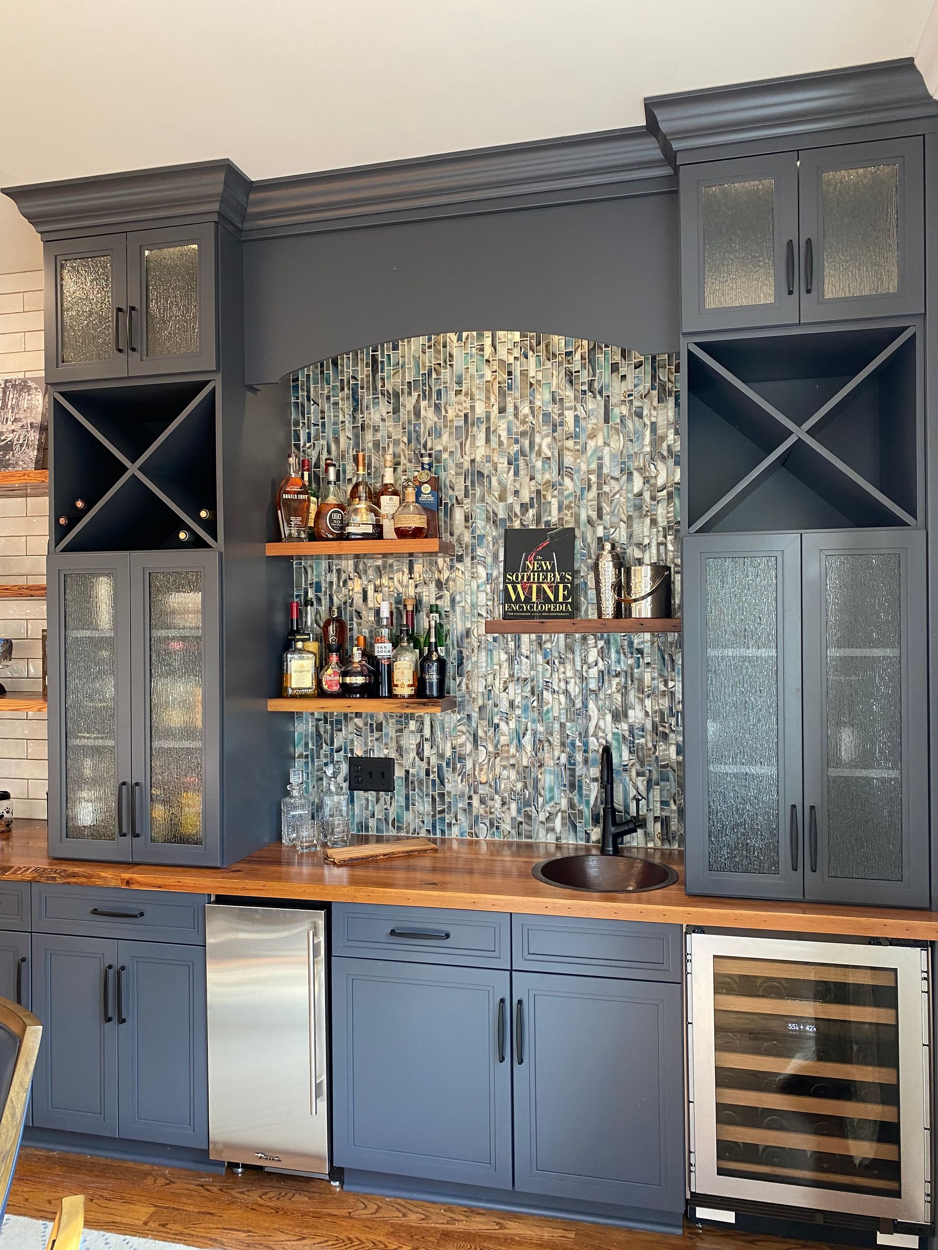 Wet bar with accent mosaic tile backsplash, built-in ice maker and wine cooler