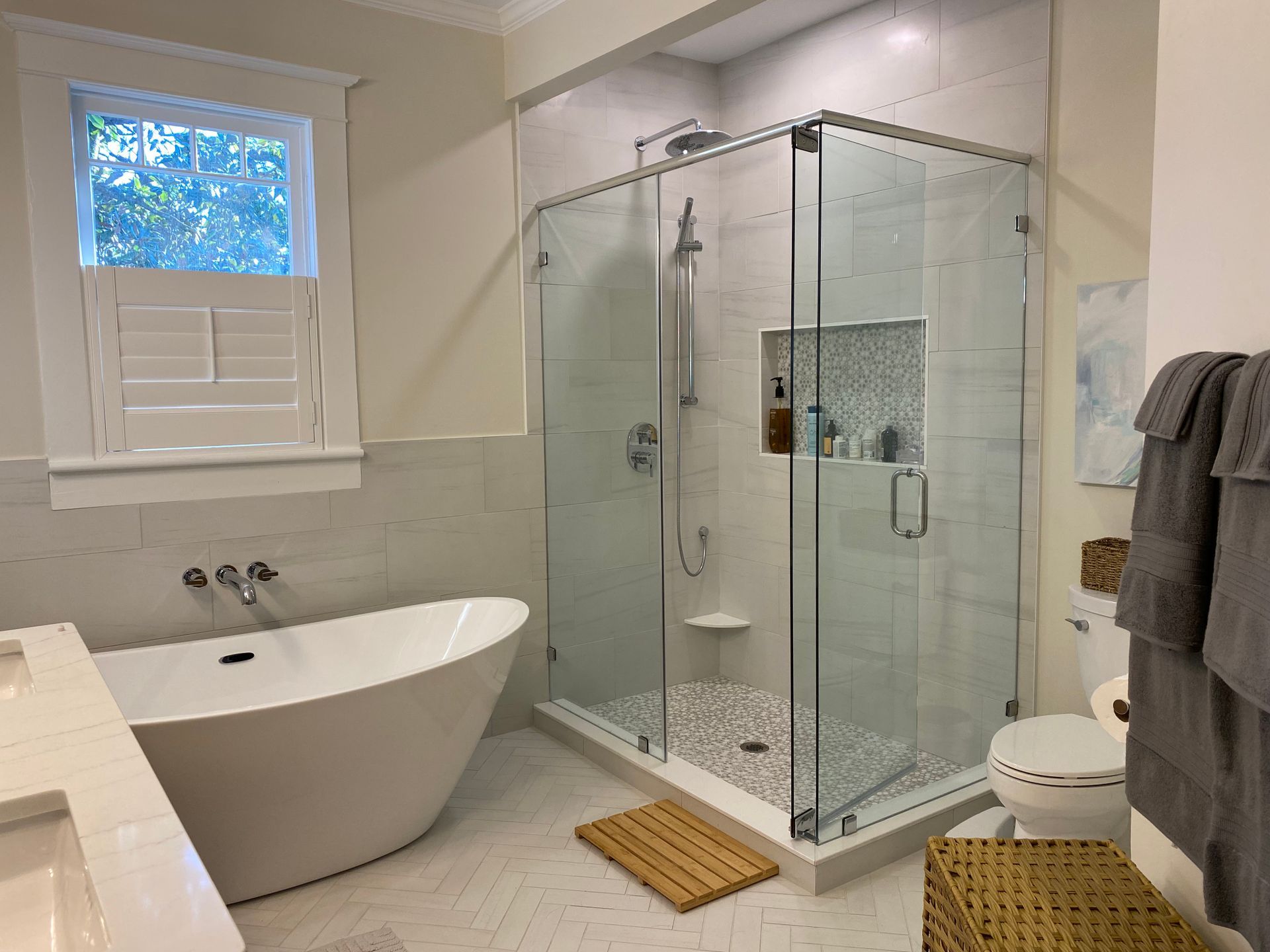 CRK Builders bathroom remodel featuring a white and grey walk-in shower and free standing tub.