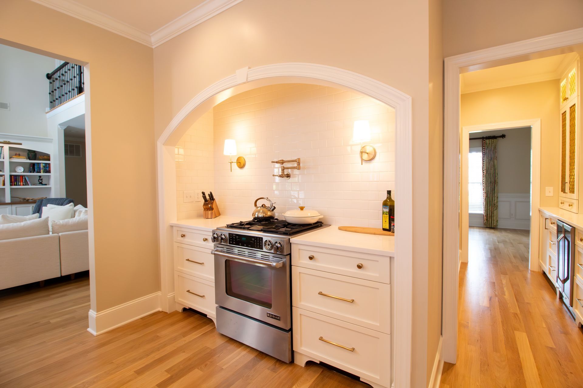 White and gold kitchen with arched cooking alcove.