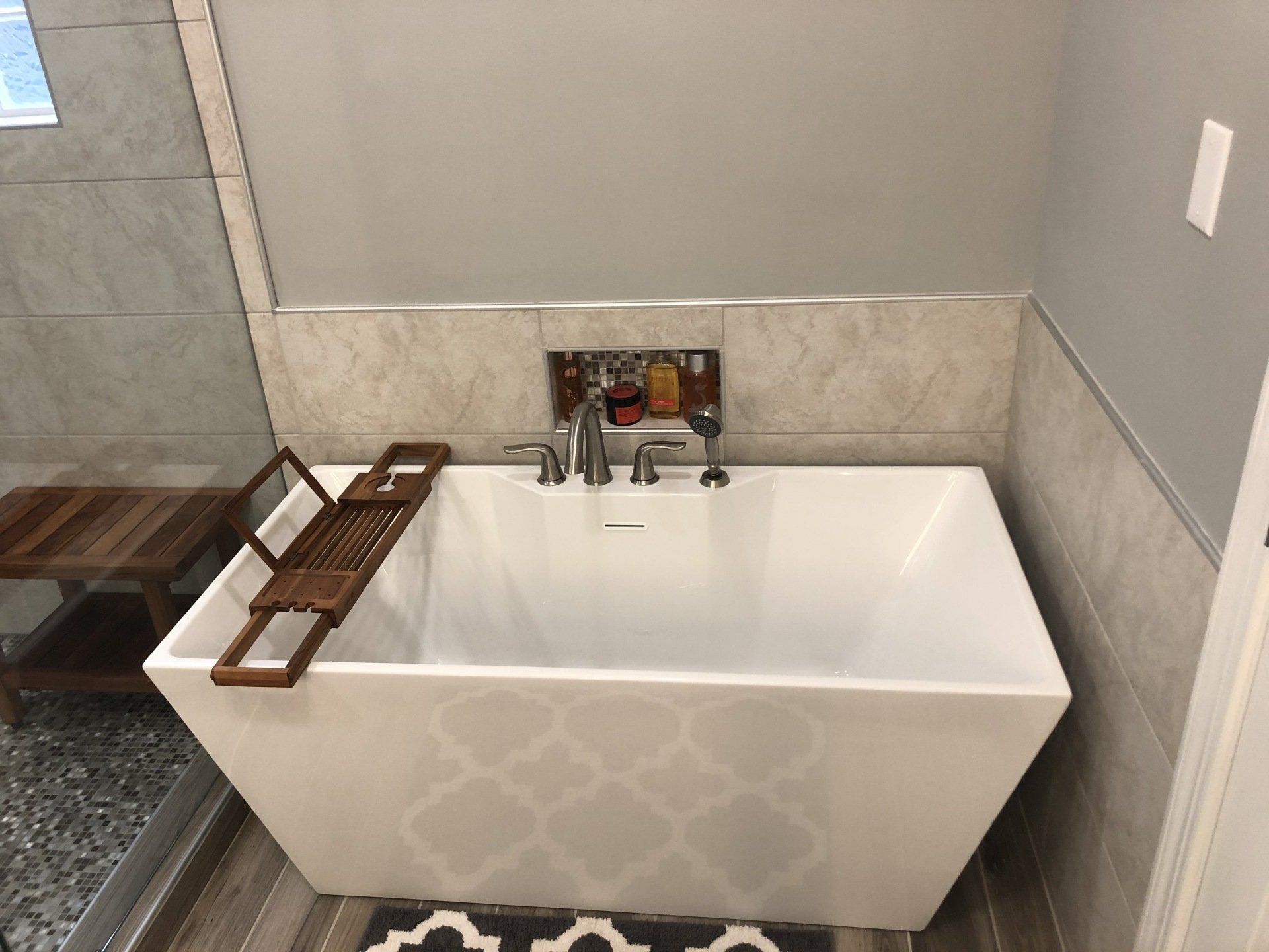 Free standing tub with built-in tub wall niche for storage.