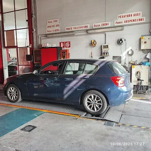 Berlina BMW M3 grigia con cerchi neri e pinze dei freni rosse parcheggiata su una strada.