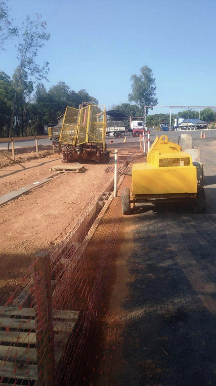 Um caminhão amarelo está dirigindo por uma estrada de terra.