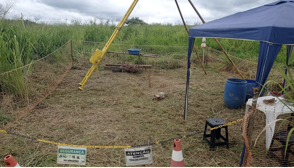Uma tenda azul está no meio de um campo.