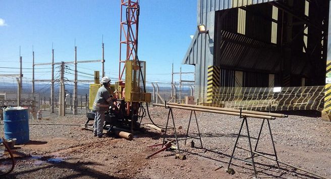 Um homem está trabalhando em uma máquina em frente a um prédio.