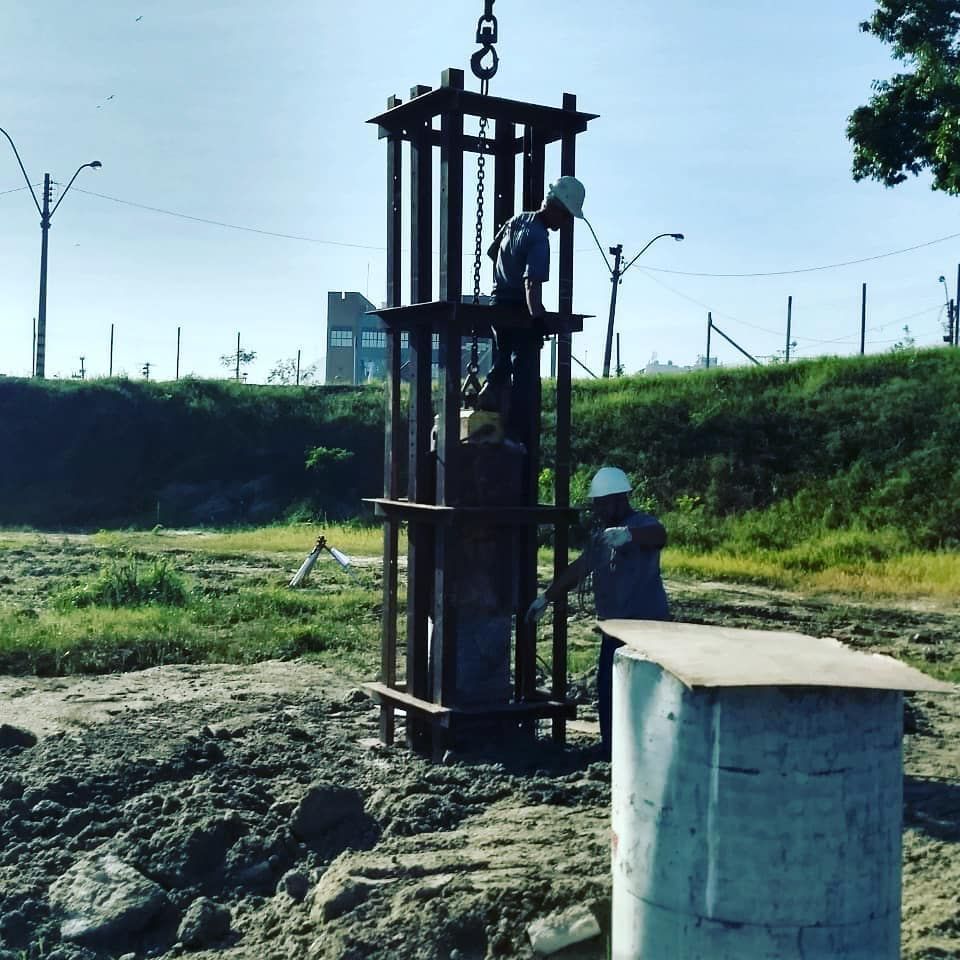 Um homem com capacete está trabalhando em uma estrutura de metal