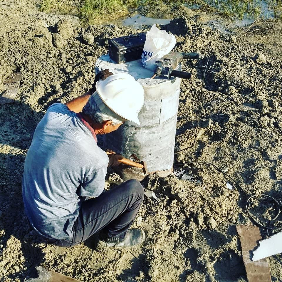 Um homem usando um capacete está trabalhando na terra