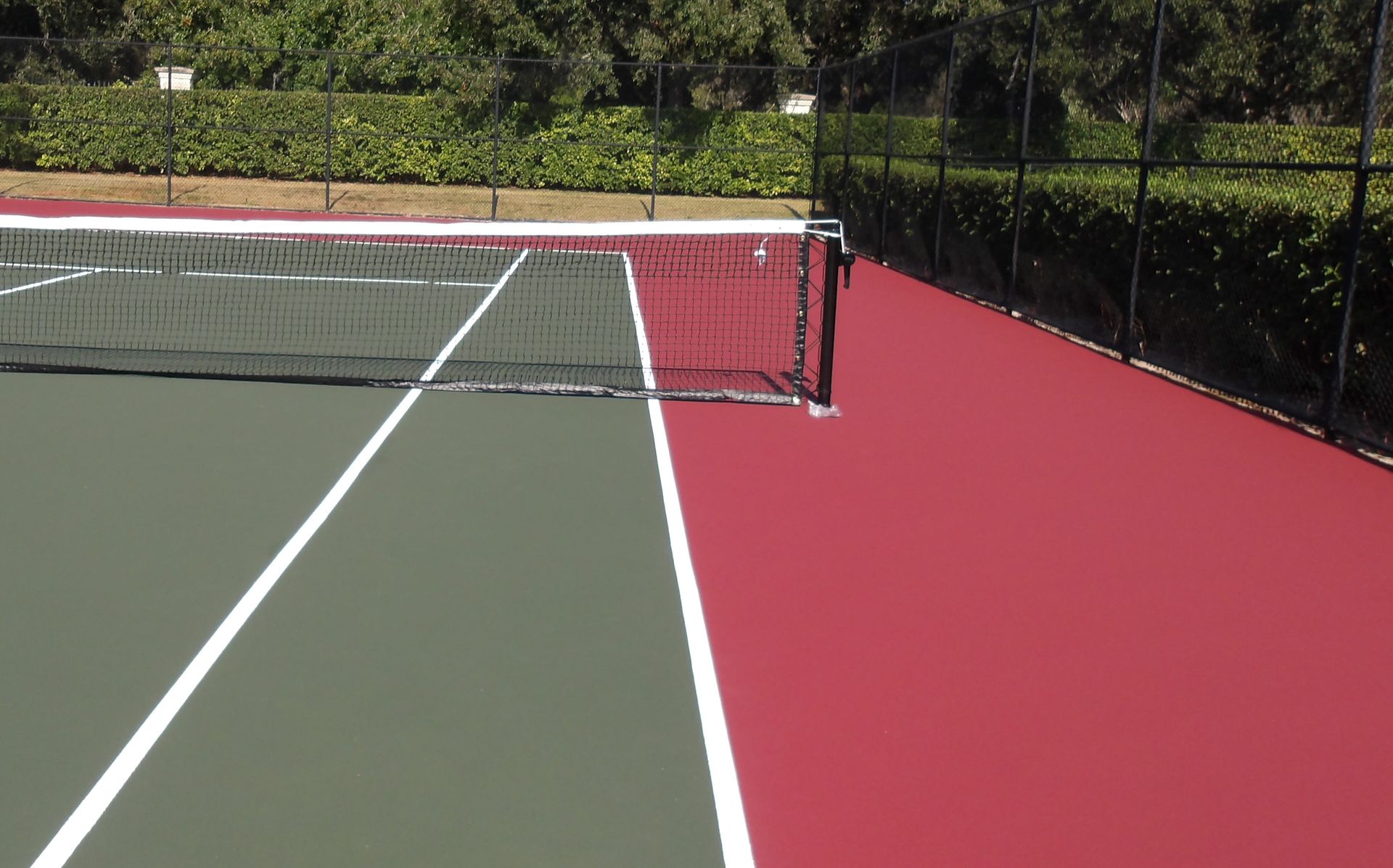Yellow pickleball on a blue court, net in background.