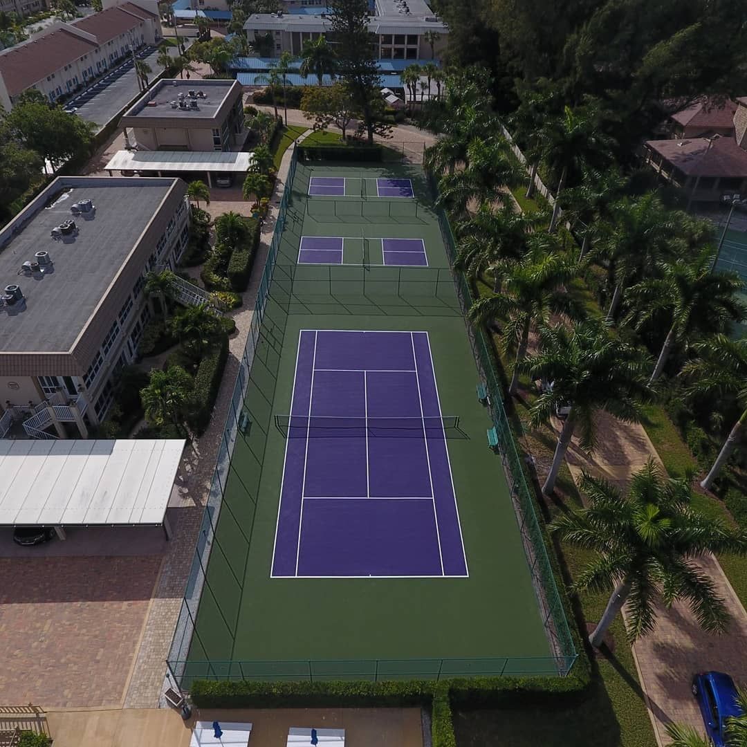 Yellow pickleball on a blue court, net in background.
