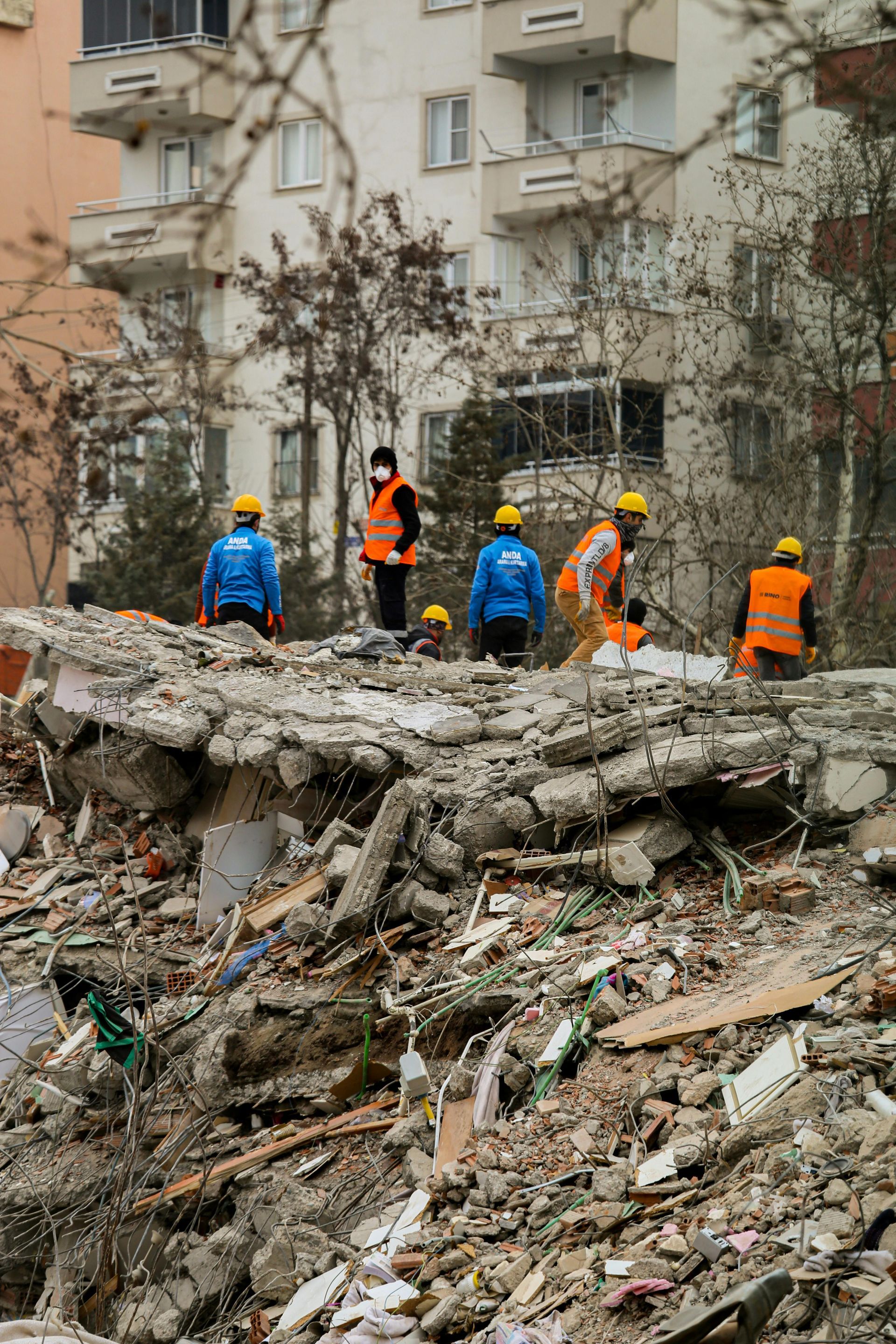 A group of people are standing on top of a pile of rubble.