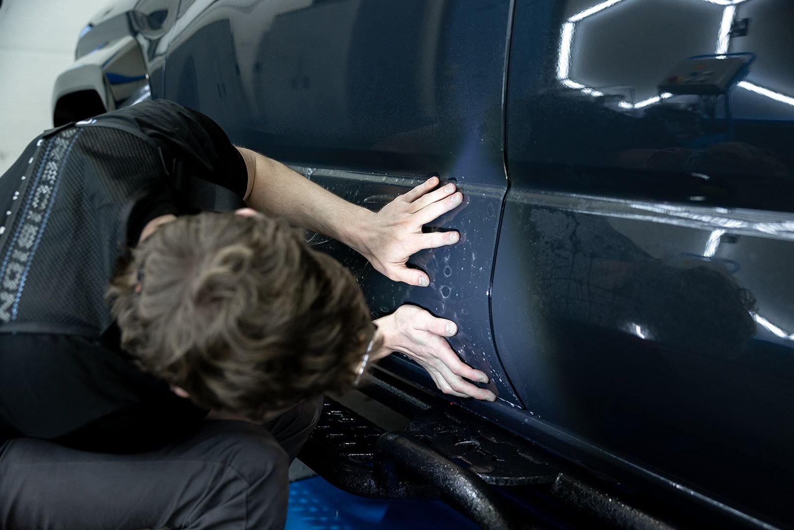 A mercedes is parked in a garage with a box on the ground in front of it