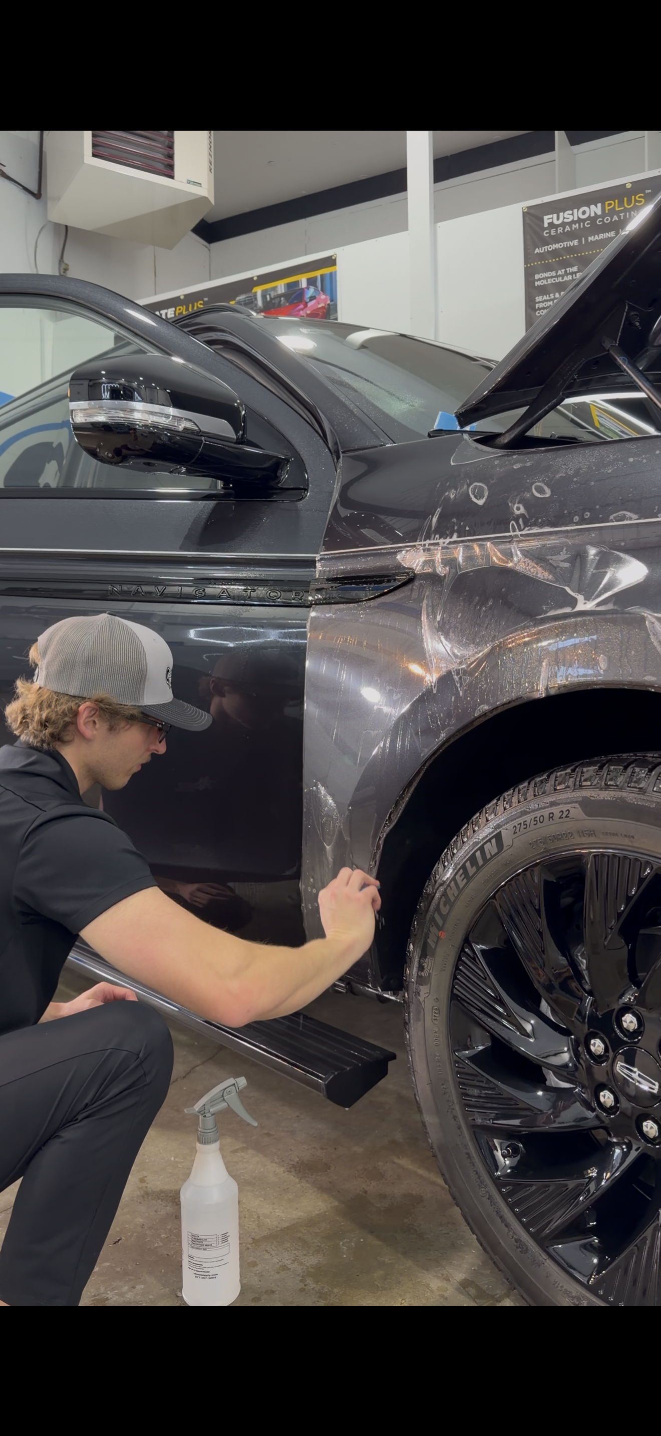 A black truck is parked in front of a building.