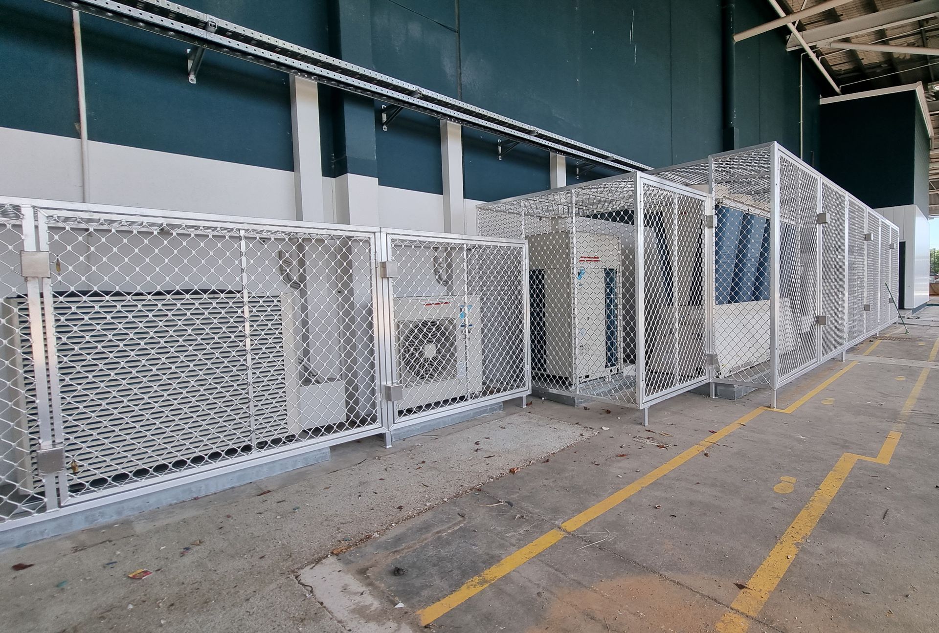 Air Conditioning Units Enclosed in A Chain-Link Fence on A Concrete Surface — Mingweld Fabrication in Bungalow, QLD