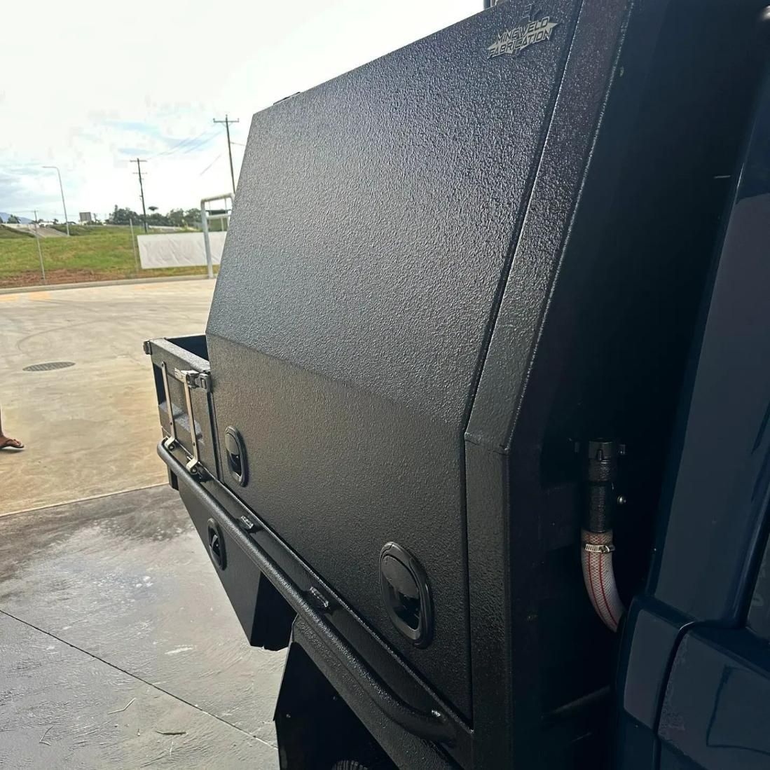 A Black Truck with A Toolbox on The Back Is Parked on The Side of The Road — Mingweld Fabrication in Bungalow, QLD