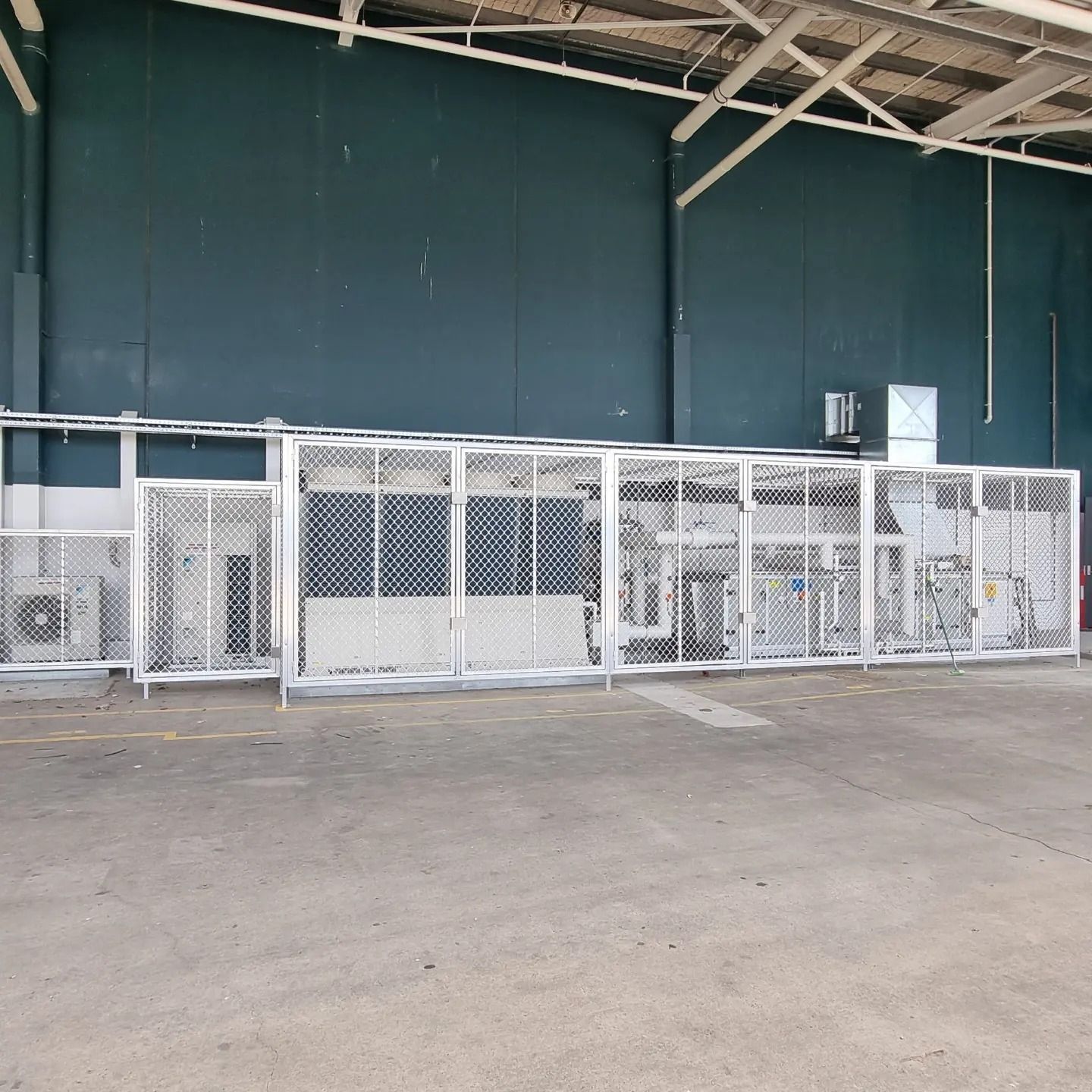 Metal Machinery Protected by A Metal Cage Within an Industrial Building — Mingweld Fabrication in Bungalow, QLD