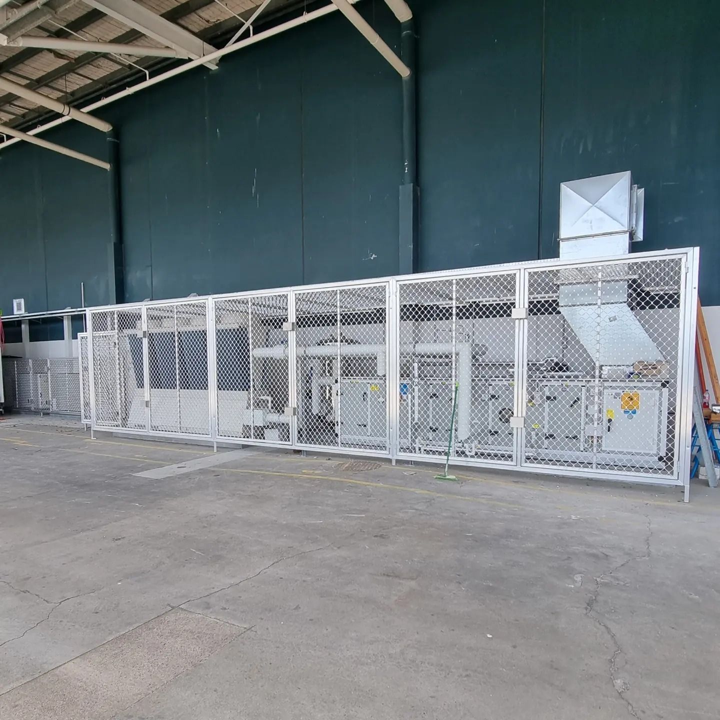 Metal Cage Enclosing Industrial Machinery in A Warehouse â Mingweld Fabrication in Bungalow, QLD