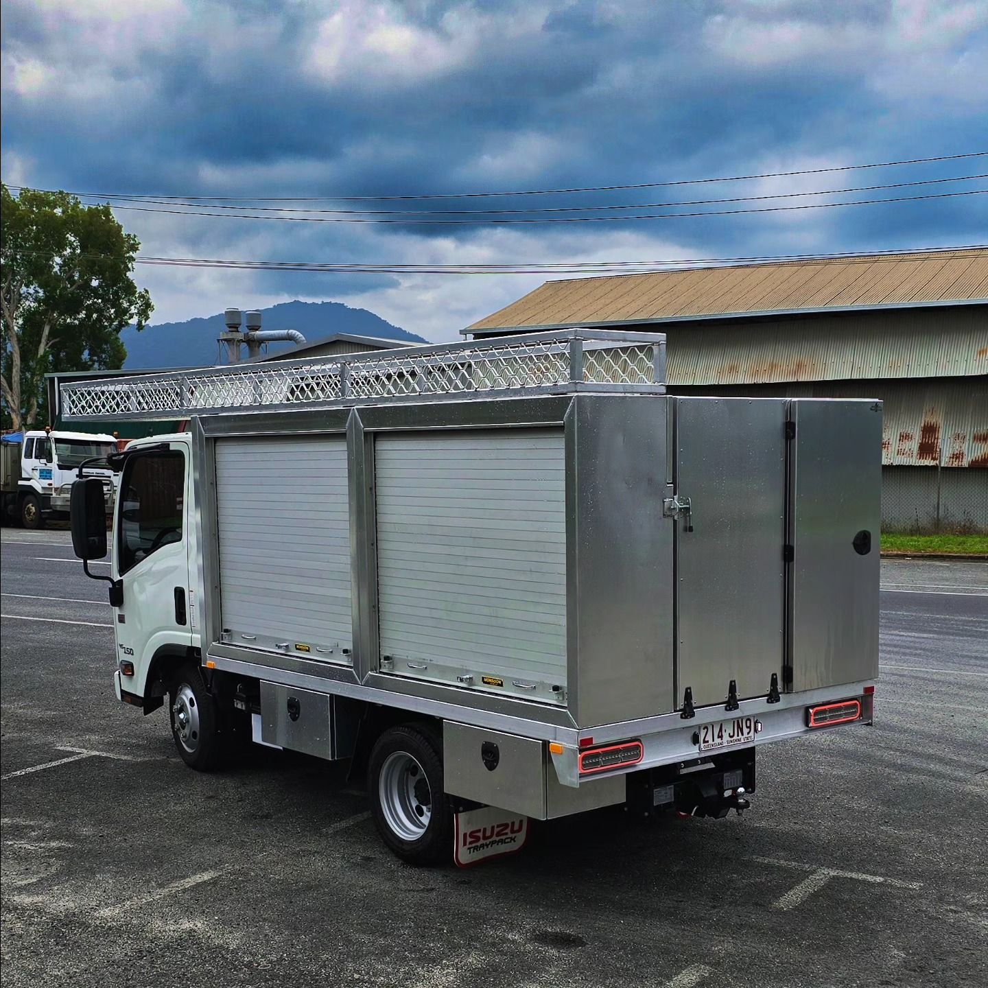 Silver Utility Truck with Roll-Up Doors, Parked on Asphalt — Mingweld Fabrication in Bungalow, QLD