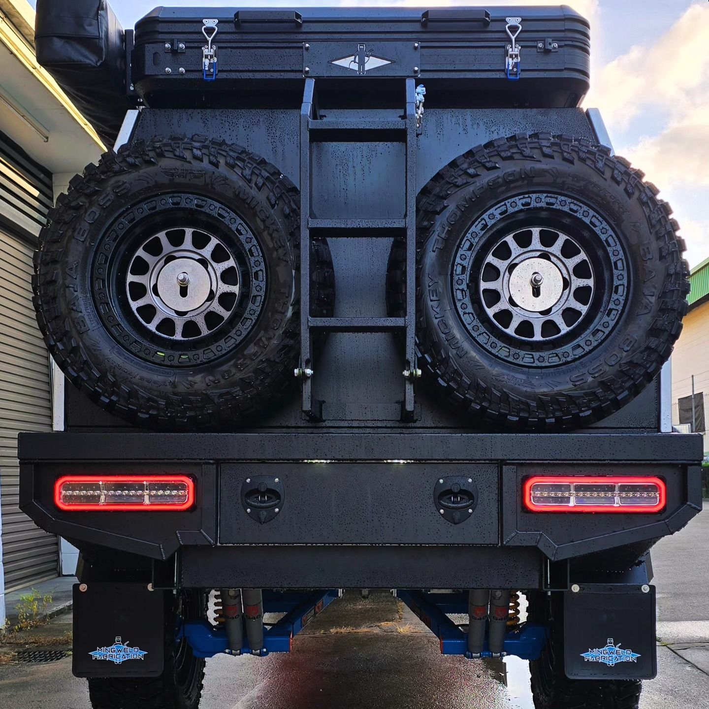 Rear View of A Black 4x4 Vehicle with Spare Tires, a Storage Box, Ladder, and A Custom Bumper — Mingweld Fabrication in Bungalow, QLD