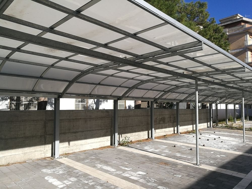 Covered Parking Area with Metal Frame and Translucent Roof. Gray Brick Ground, Concrete Wall, Sunny Outdoor Setting — Mingweld Fabrication in Bungalow, QLD