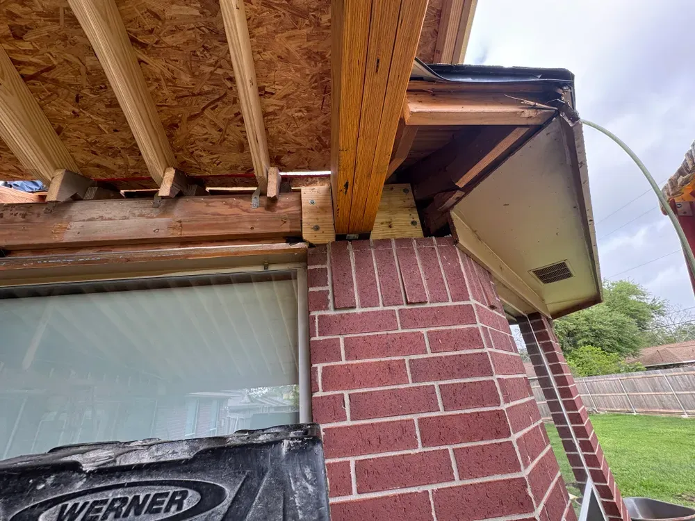 Construction: Wood beam supported on a brick column, new roof framing visible.