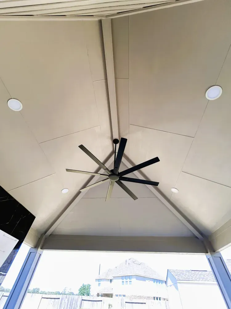 Covered patio ceiling with fan and recessed lights; beige walls, black fan blades.