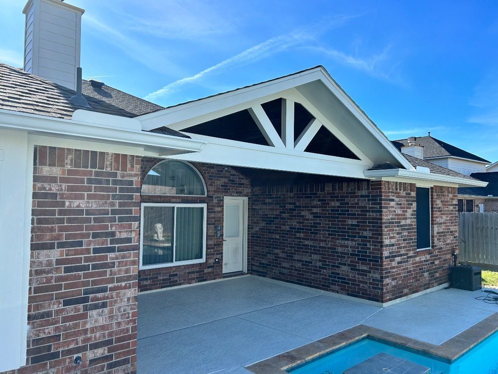 Brick home exterior with pool, featuring a white gable and black accents.