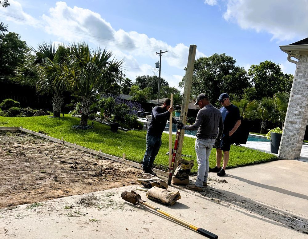 Three men installing a wooden post in a yard. One uses a level. Sunny day.