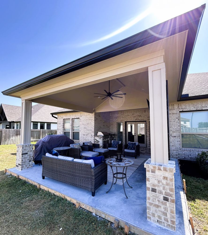 Covered outdoor patio with seating, light brick, and gray concrete floor.