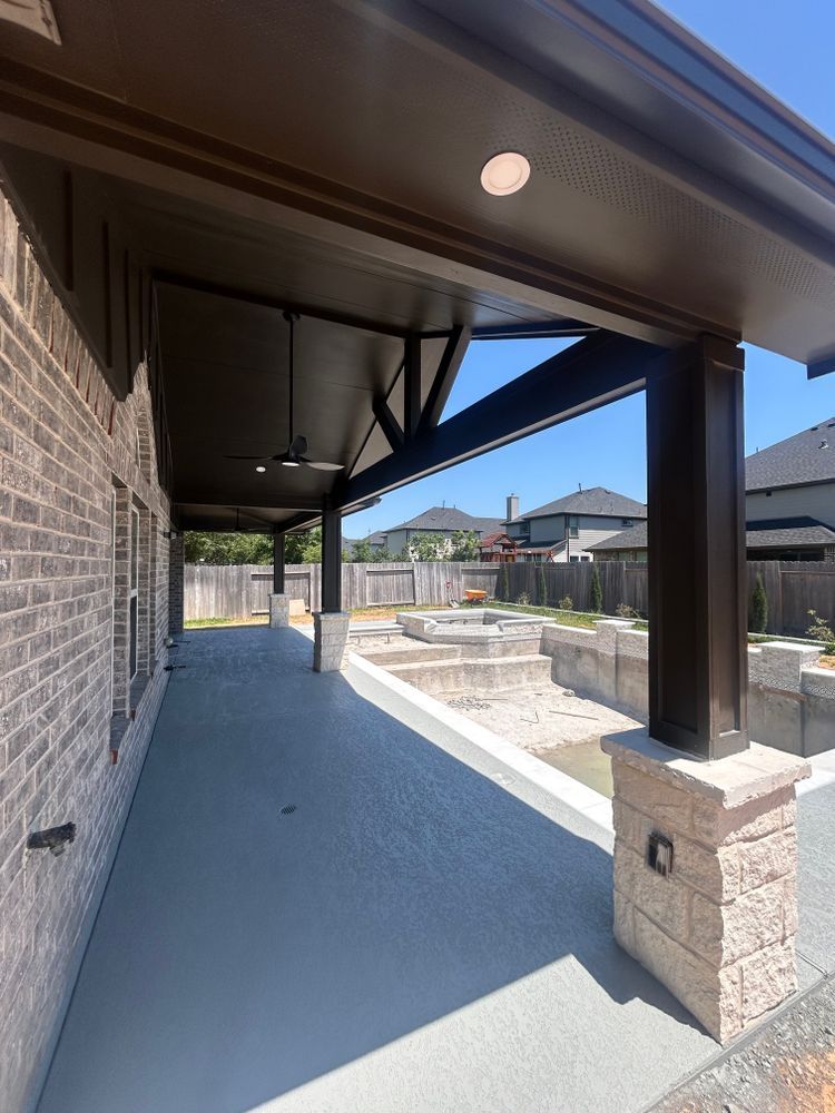 Covered patio with dark brown beams, gray floor, and view of a pool.