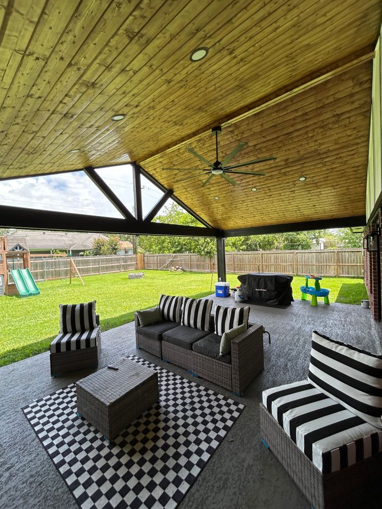 Patio with outdoor furniture, black and white rug, and a view of a backyard with a swing set.