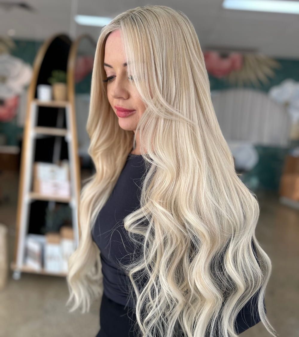 A Woman With Long Blonde Hair is Wearing a Black Dress — Tree House Salon In Nerang, QLD