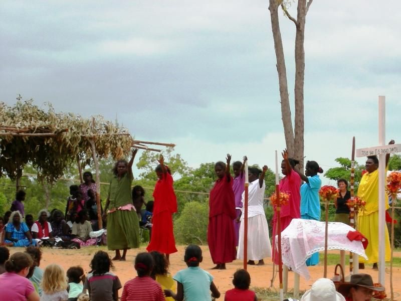 A group of people standing in front of a cross