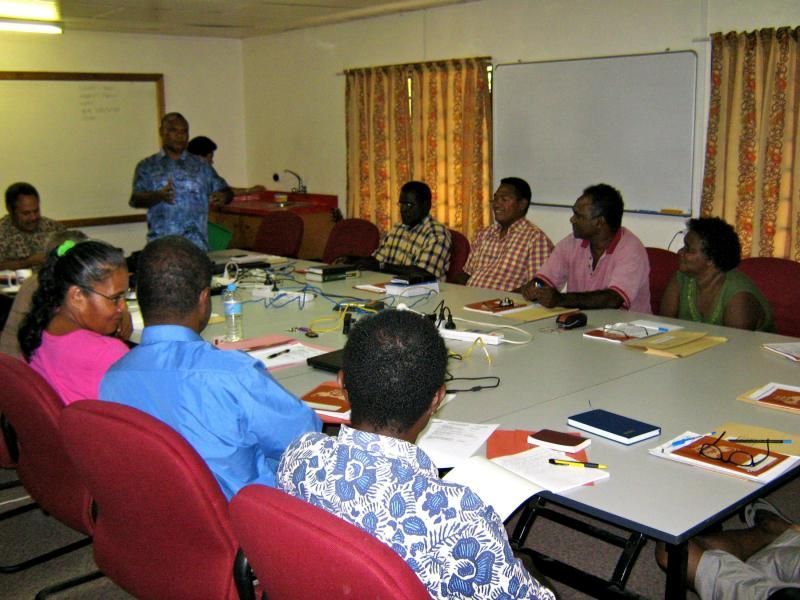 A group of people sitting around a table with papers on it