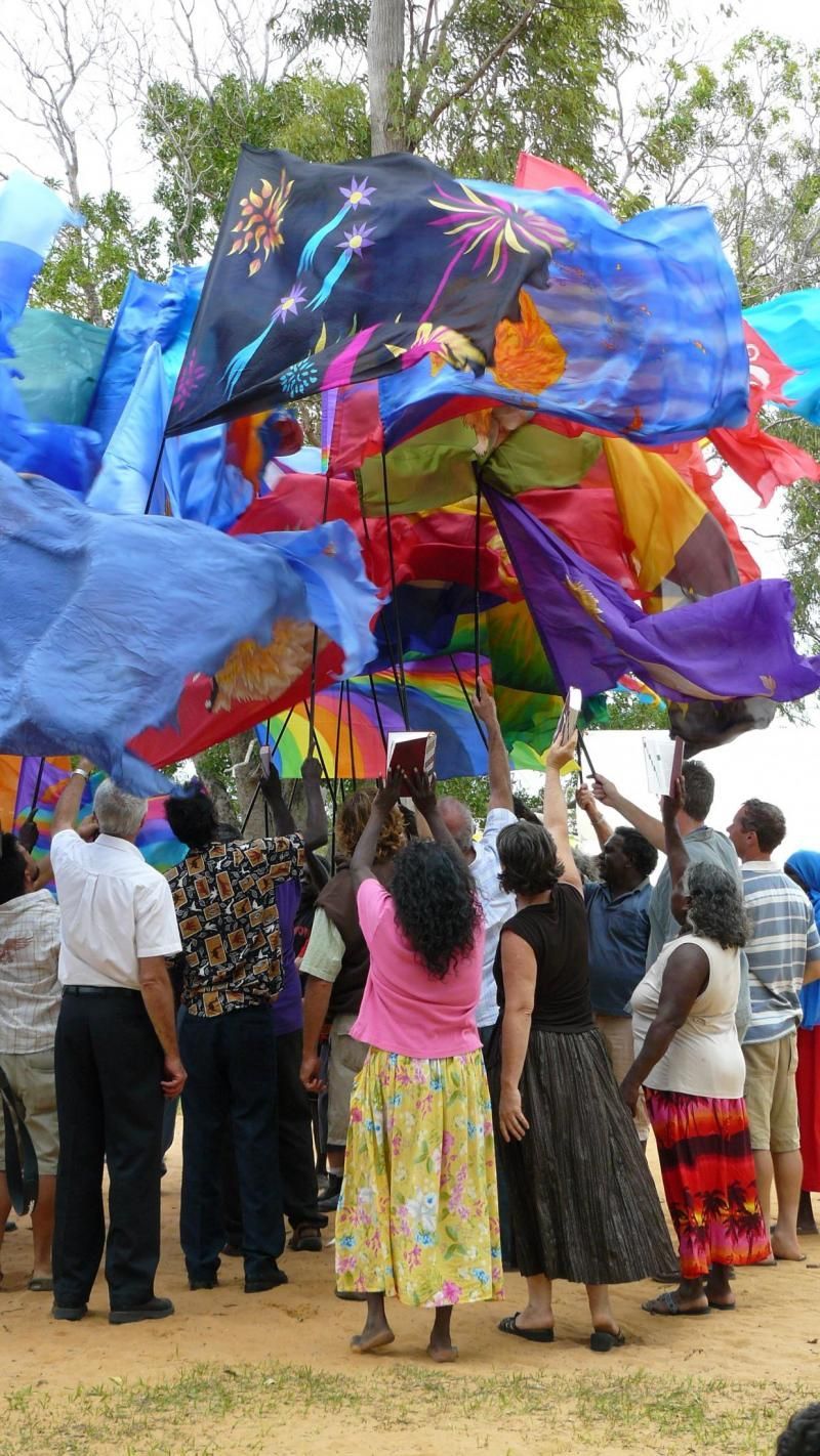 A group of people are standing around a bunch of colorful flags