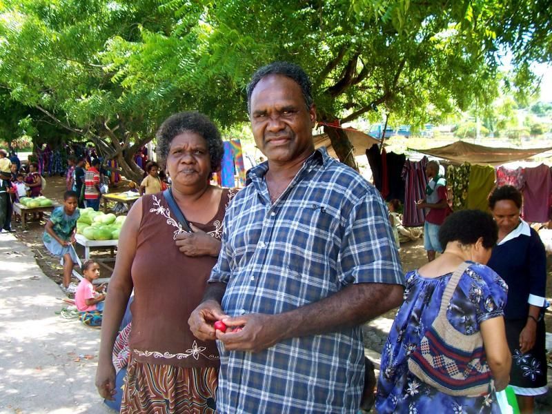 A man and woman are posing for a picture at a market