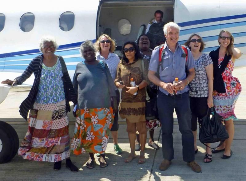 A group of people standing in front of an airplane