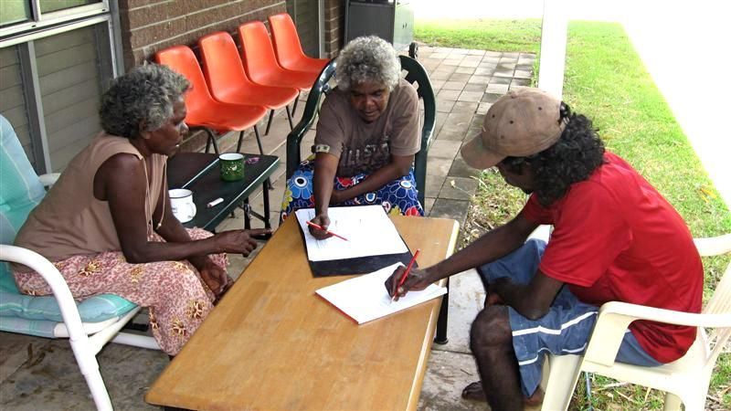 A group of people are sitting around a table with papers on it
