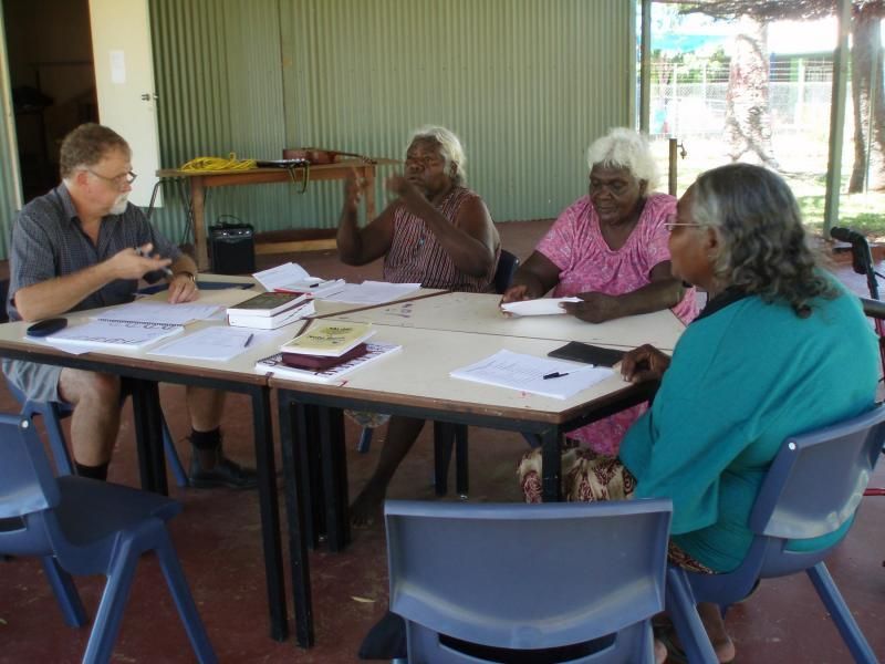 A group of people are sitting around a table talking