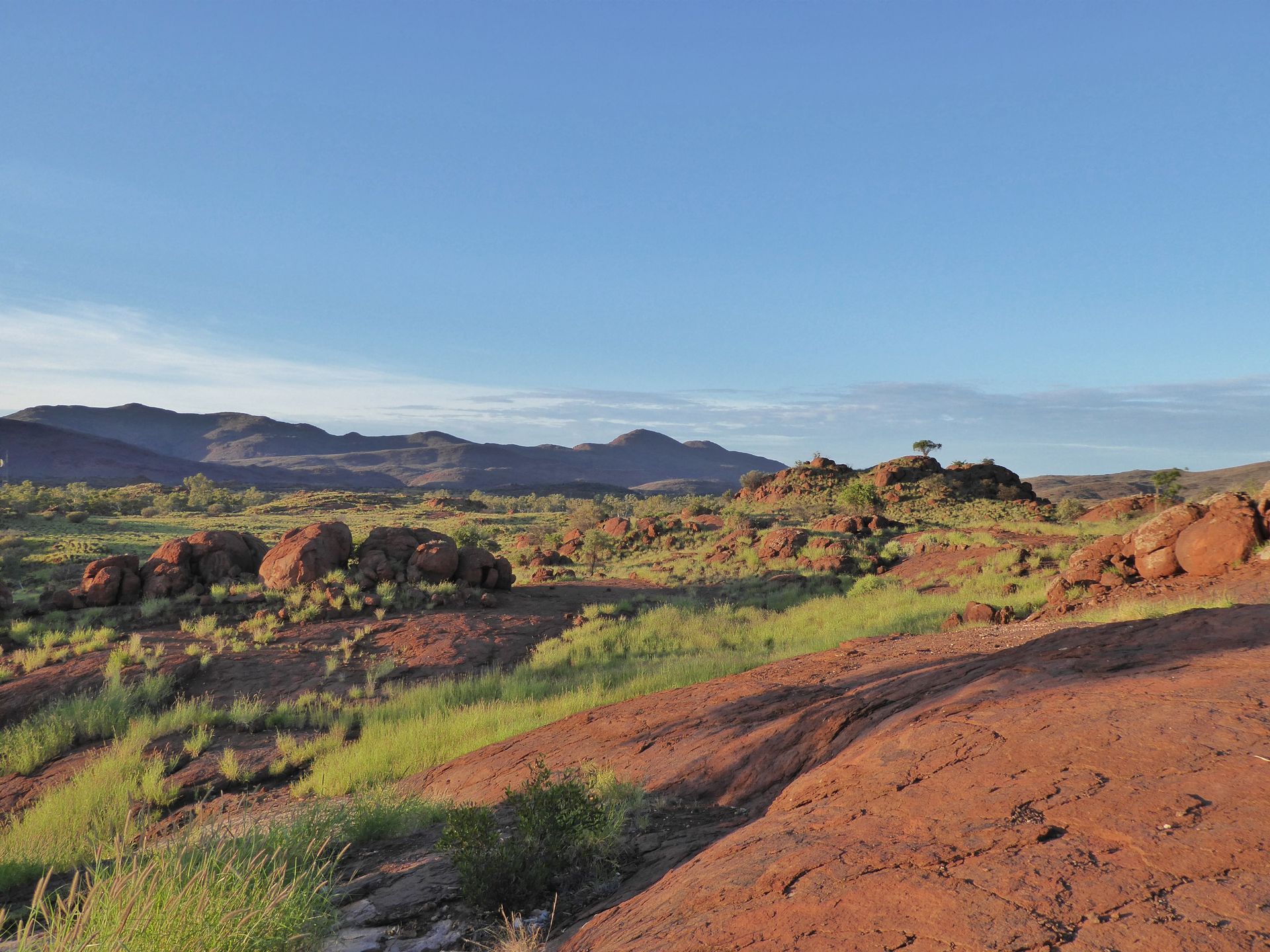 A desert landscape with mountains in the background and a blue sky