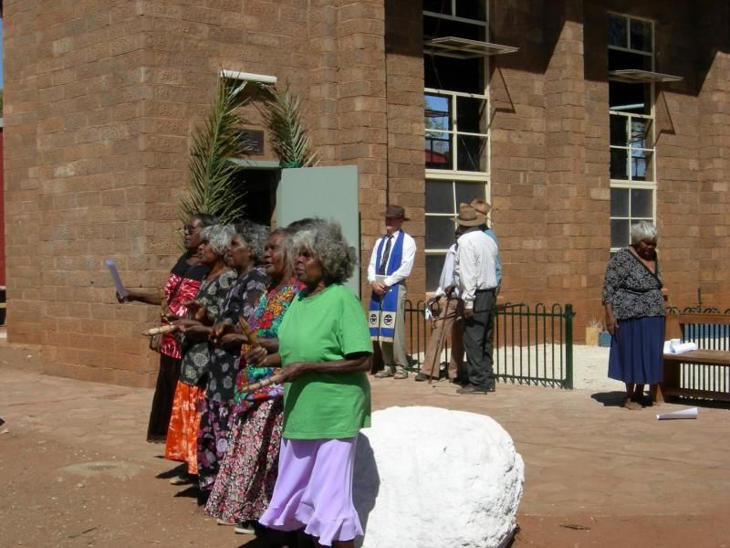 A group of people standing in front of a brick building
